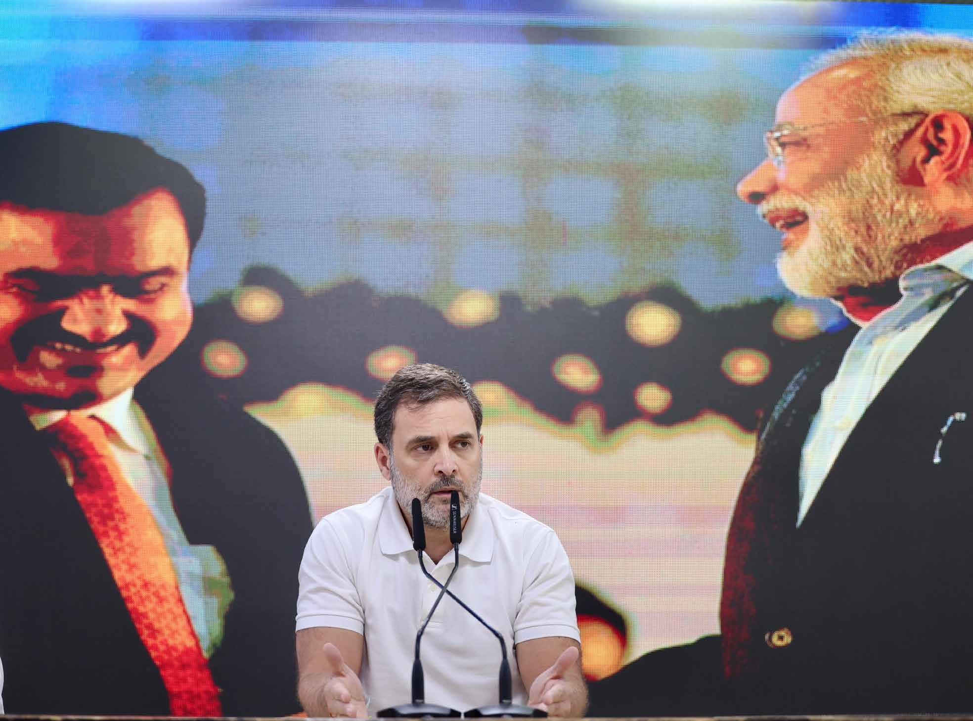 Video still of Rahul Gandhi at a press conference in front of an Adani-Modi backdrop